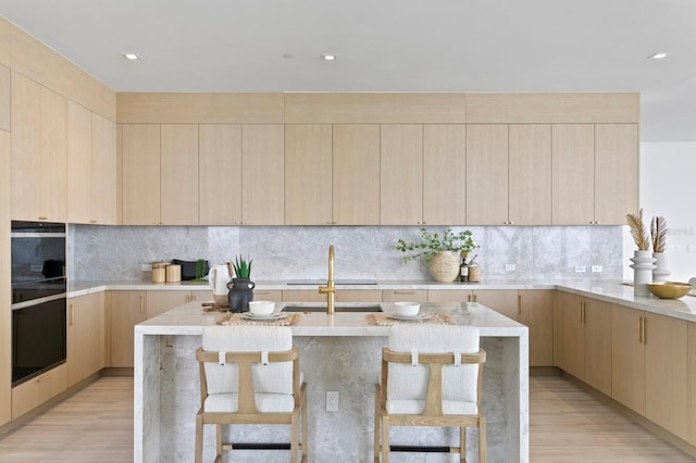 kitchen with a kitchen island, light brown cabinetry, and light hardwood / wood-style floors