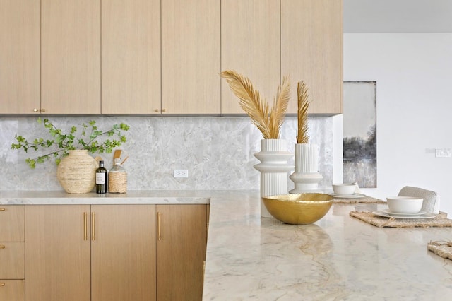 details with light brown cabinetry, light stone counters, and decorative backsplash