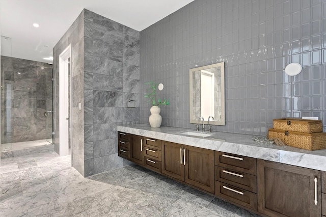 bathroom with tile walls, an enclosed shower, and vanity