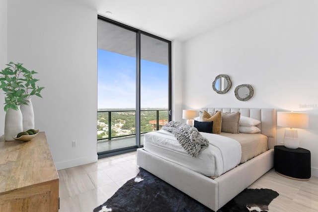 bedroom with a wall of windows and access to exterior