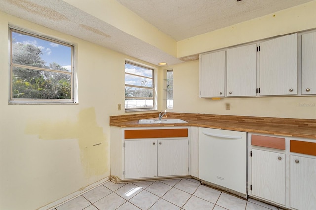 kitchen with a wealth of natural light, white cabinetry, sink, and white dishwasher