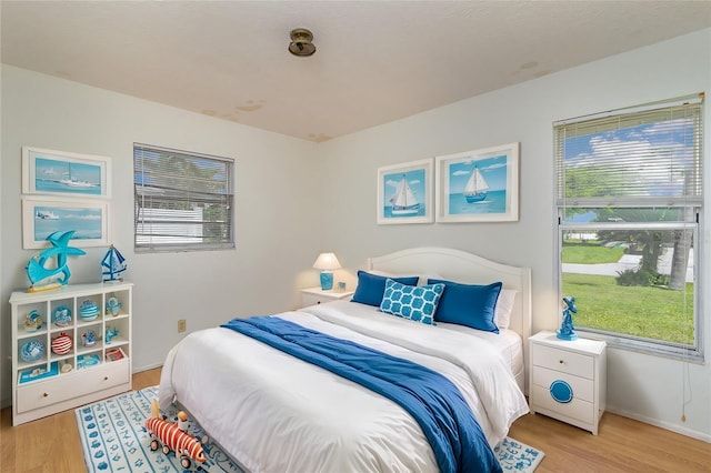 bedroom featuring multiple windows and light hardwood / wood-style flooring