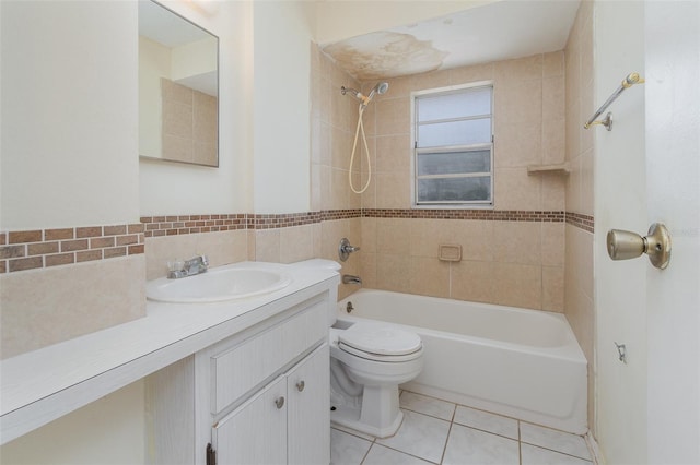 full bathroom featuring tile patterned flooring, vanity, tiled shower / bath combo, and toilet