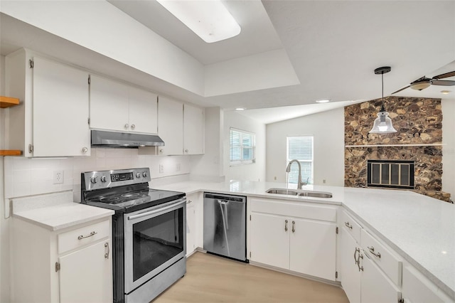 kitchen featuring white cabinets, stainless steel appliances, lofted ceiling, decorative light fixtures, and sink