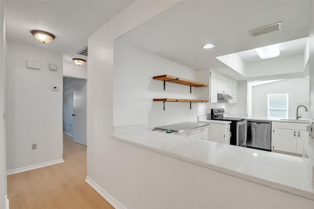 kitchen featuring white cabinets, sink, light hardwood / wood-style flooring, stainless steel appliances, and light stone countertops