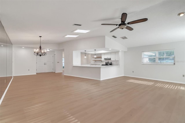 unfurnished living room with ceiling fan with notable chandelier, lofted ceiling, and light hardwood / wood-style floors