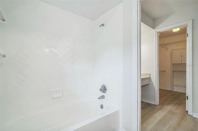 bathroom with vanity, hardwood / wood-style floors, and tiled shower / bath