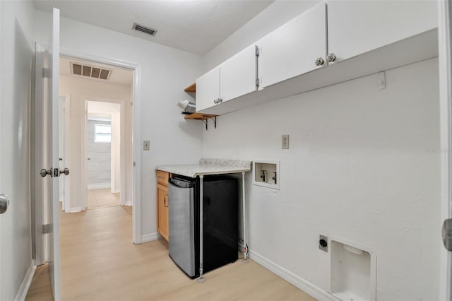 clothes washing area featuring washer hookup, cabinets, light wood-type flooring, and hookup for an electric dryer