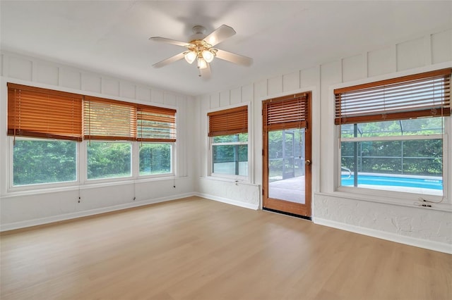 unfurnished room featuring wood-type flooring, ceiling fan, and a wealth of natural light