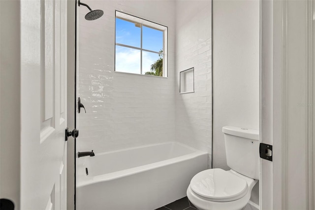 bathroom with toilet and tiled shower / bath combo