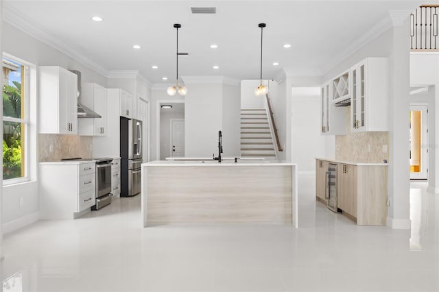 kitchen featuring tasteful backsplash, white cabinetry, appliances with stainless steel finishes, decorative light fixtures, and light tile patterned floors