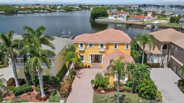 view of front of house featuring decorative driveway, a water view, and stucco siding