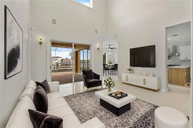 living area with visible vents, a wealth of natural light, and a ceiling fan