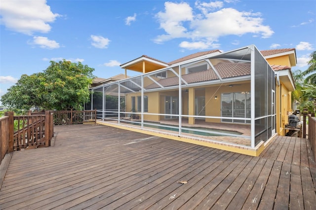 wooden terrace with a fenced in pool and glass enclosure