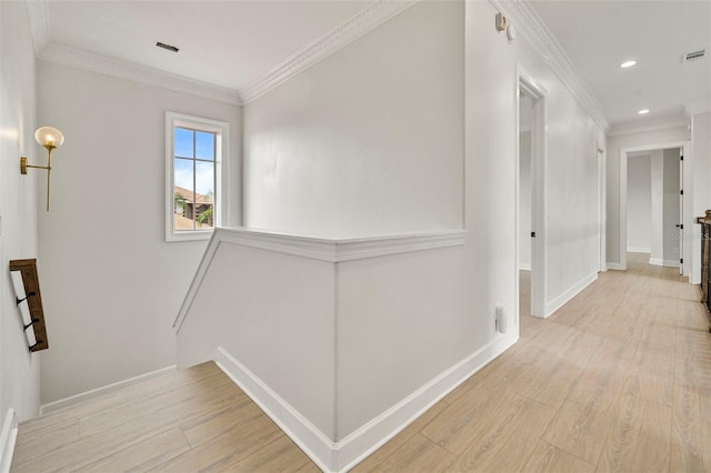 corridor with light wood-type flooring, baseboards, ornamental molding, and an upstairs landing