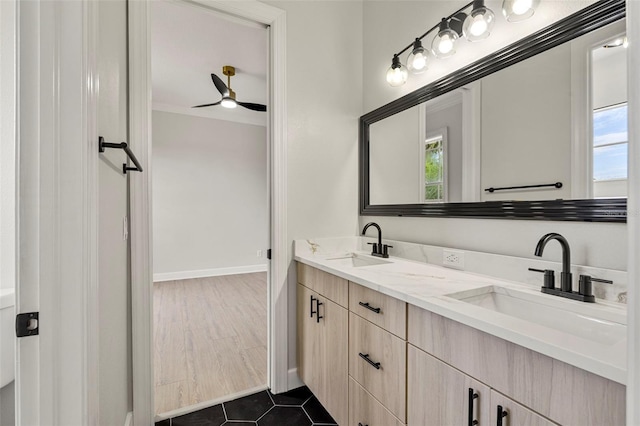 bathroom with double vanity, baseboards, and a ceiling fan