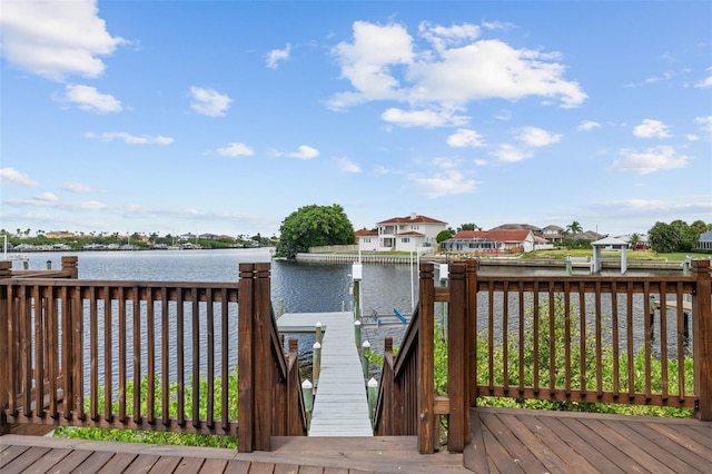deck featuring a water view, a dock, and a residential view