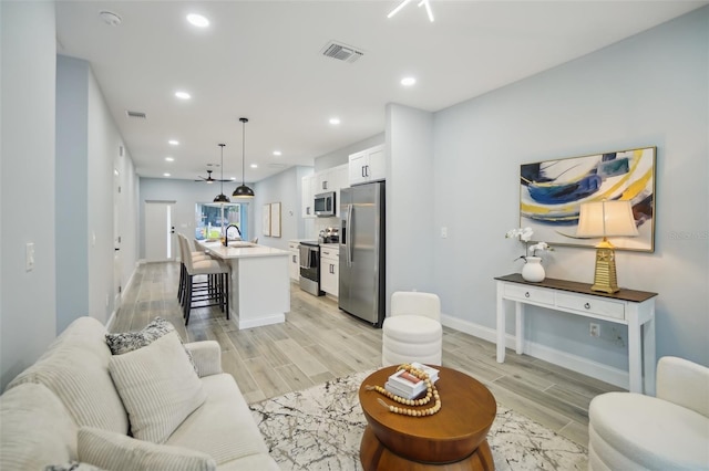 living room with baseboards, recessed lighting, visible vents, and wood tiled floor