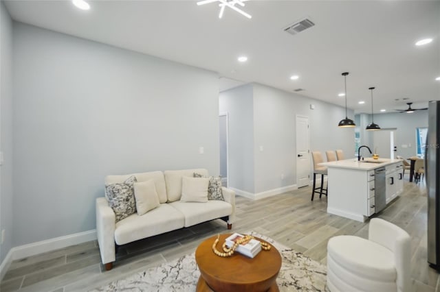 living area featuring light wood finished floors, baseboards, visible vents, and recessed lighting