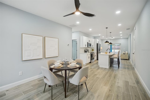 dining room with light wood-style floors, baseboards, visible vents, and recessed lighting