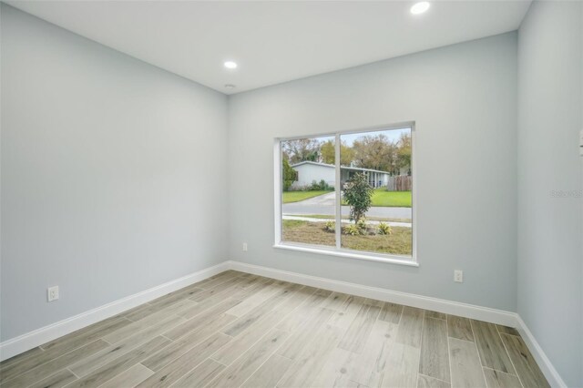 empty room featuring recessed lighting, light wood-style flooring, and baseboards