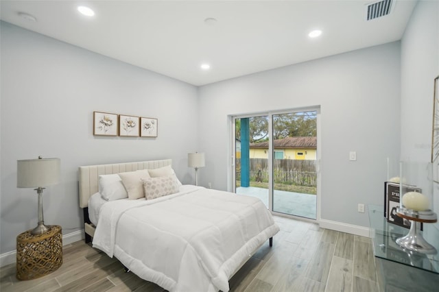 bedroom featuring access to exterior, visible vents, light wood-style floors, and baseboards