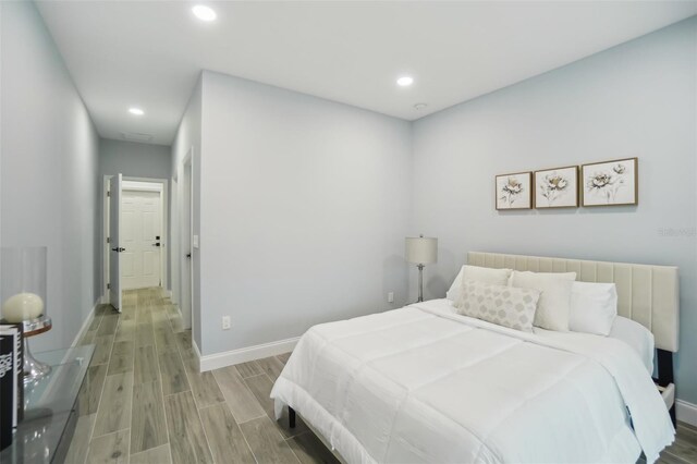 bedroom with wood tiled floor, baseboards, and recessed lighting