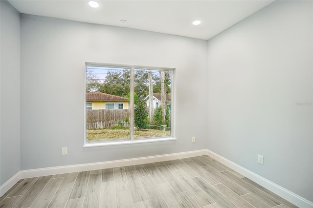 spare room with light wood-type flooring, baseboards, and recessed lighting