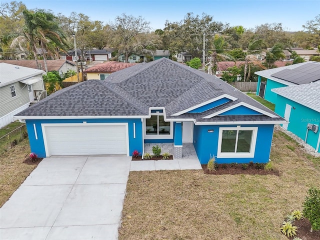 view of front of property with an attached garage, roof with shingles, fence, and a front yard