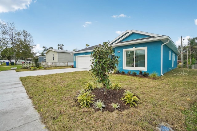 view of front of house with a garage, concrete driveway, a front lawn, and stucco siding