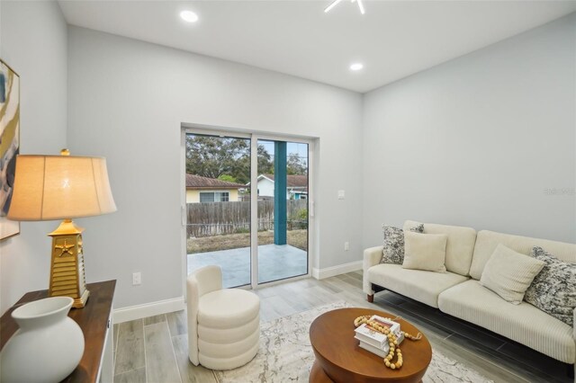 living room featuring recessed lighting, baseboards, and wood finished floors