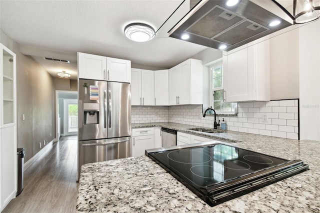 kitchen with white cabinets, light stone counters, appliances with stainless steel finishes, and sink