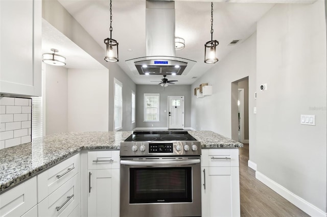 kitchen featuring electric stove, pendant lighting, island range hood, and white cabinetry