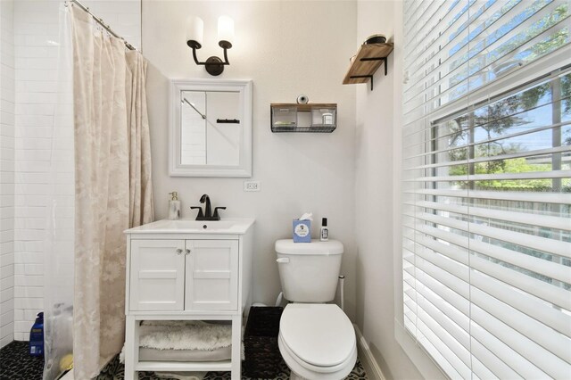 bathroom featuring curtained shower, vanity, and toilet