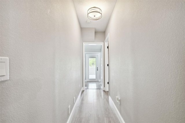 corridor with light hardwood / wood-style flooring