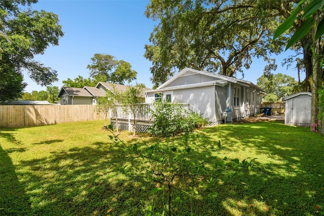 view of yard featuring a wooden deck and a shed