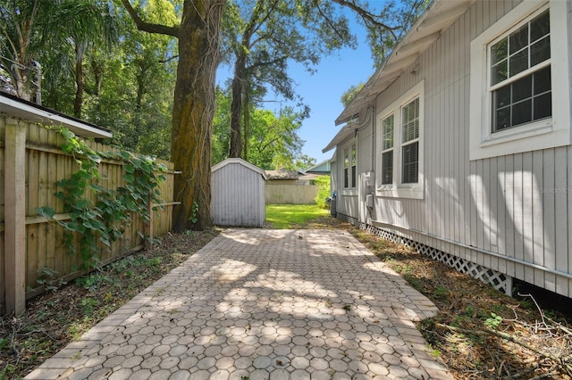 view of yard with a storage shed and a patio area