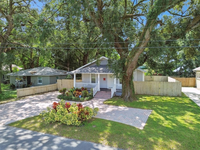 single story home featuring a front lawn and covered porch