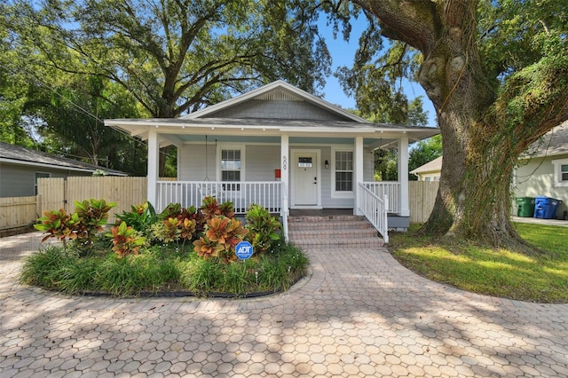 bungalow-style home featuring a porch and fence