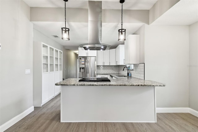 kitchen featuring stainless steel fridge, a sink, decorative backsplash, and light stone countertops