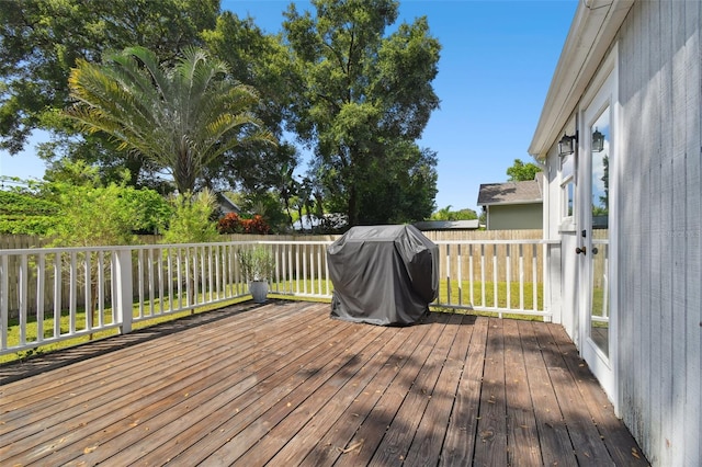 wooden deck featuring a grill and fence