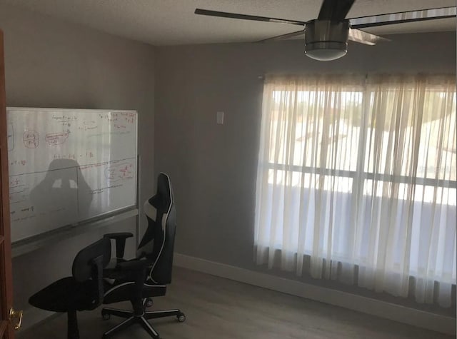 home office with wood-type flooring, ceiling fan, and a textured ceiling