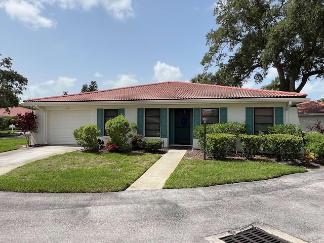 single story home featuring a garage and a front lawn