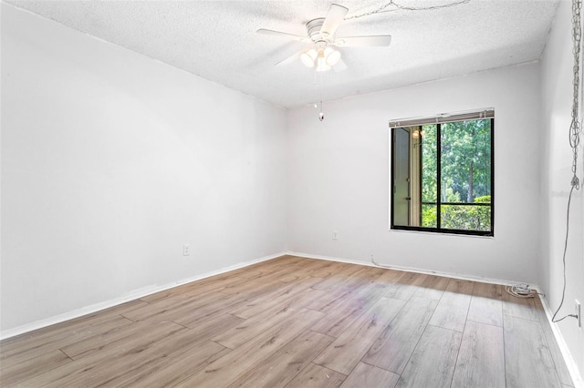 empty room featuring a ceiling fan, wood finished floors, and a textured ceiling