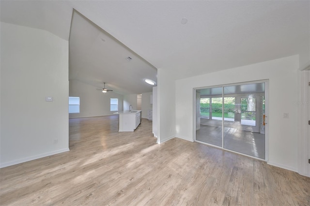 unfurnished living room featuring light hardwood / wood-style flooring, ceiling fan, and lofted ceiling