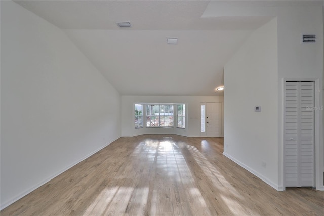 unfurnished living room featuring light hardwood / wood-style floors and vaulted ceiling