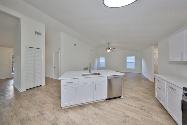 kitchen with stainless steel dishwasher, ceiling fan, sink, white cabinets, and lofted ceiling