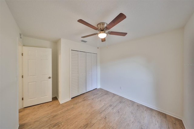 unfurnished bedroom with ceiling fan, light hardwood / wood-style floors, and a closet