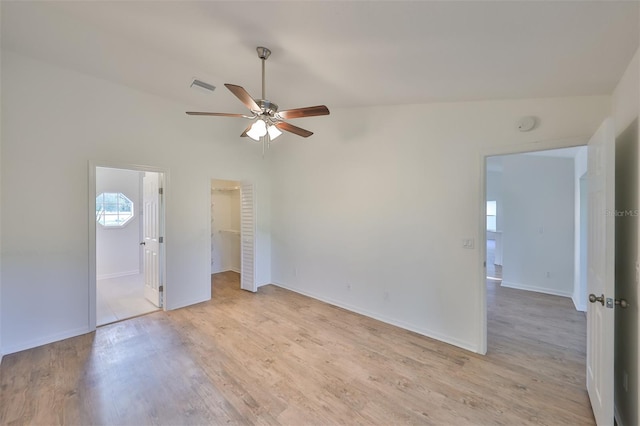 unfurnished room with ceiling fan, lofted ceiling, and light wood-type flooring