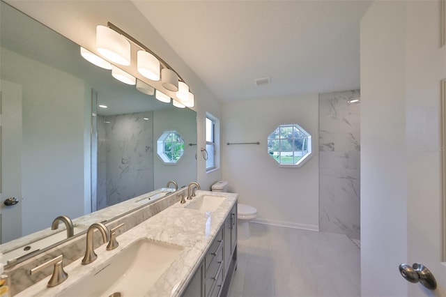 bathroom with vanity, toilet, and tiled shower